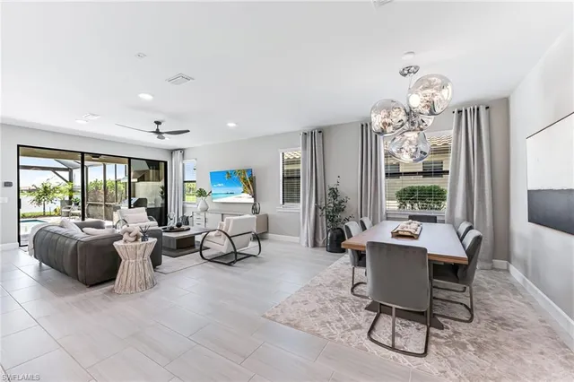a living room with furniture a flat screen tv and a large window