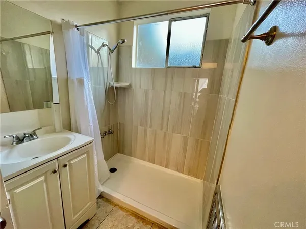 a view of a hallway with wooden floor and a bathroom