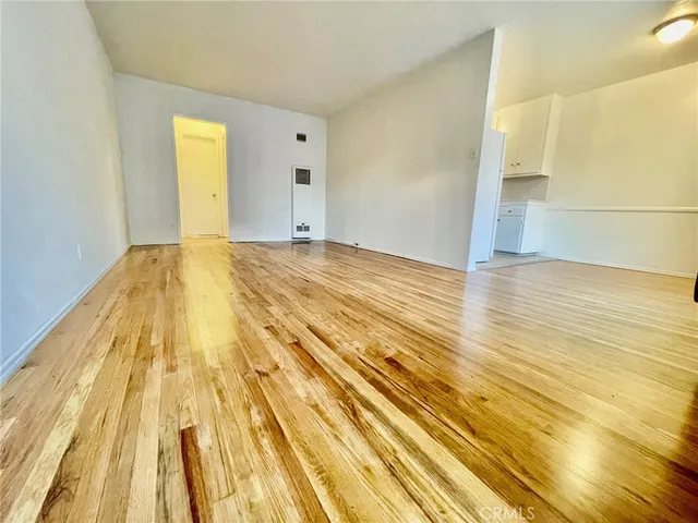 a view of an empty room and wooden floor