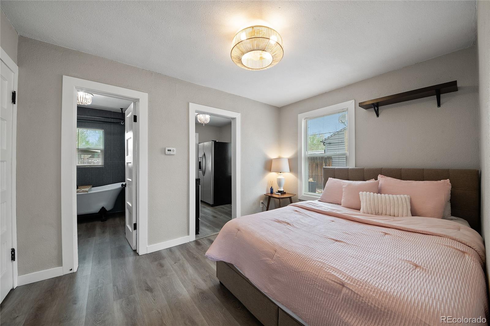 2045 Eaton Street Edgewater, CO 80214 - Photo 12 of 28 a bedroom with a bed and a chandelier
