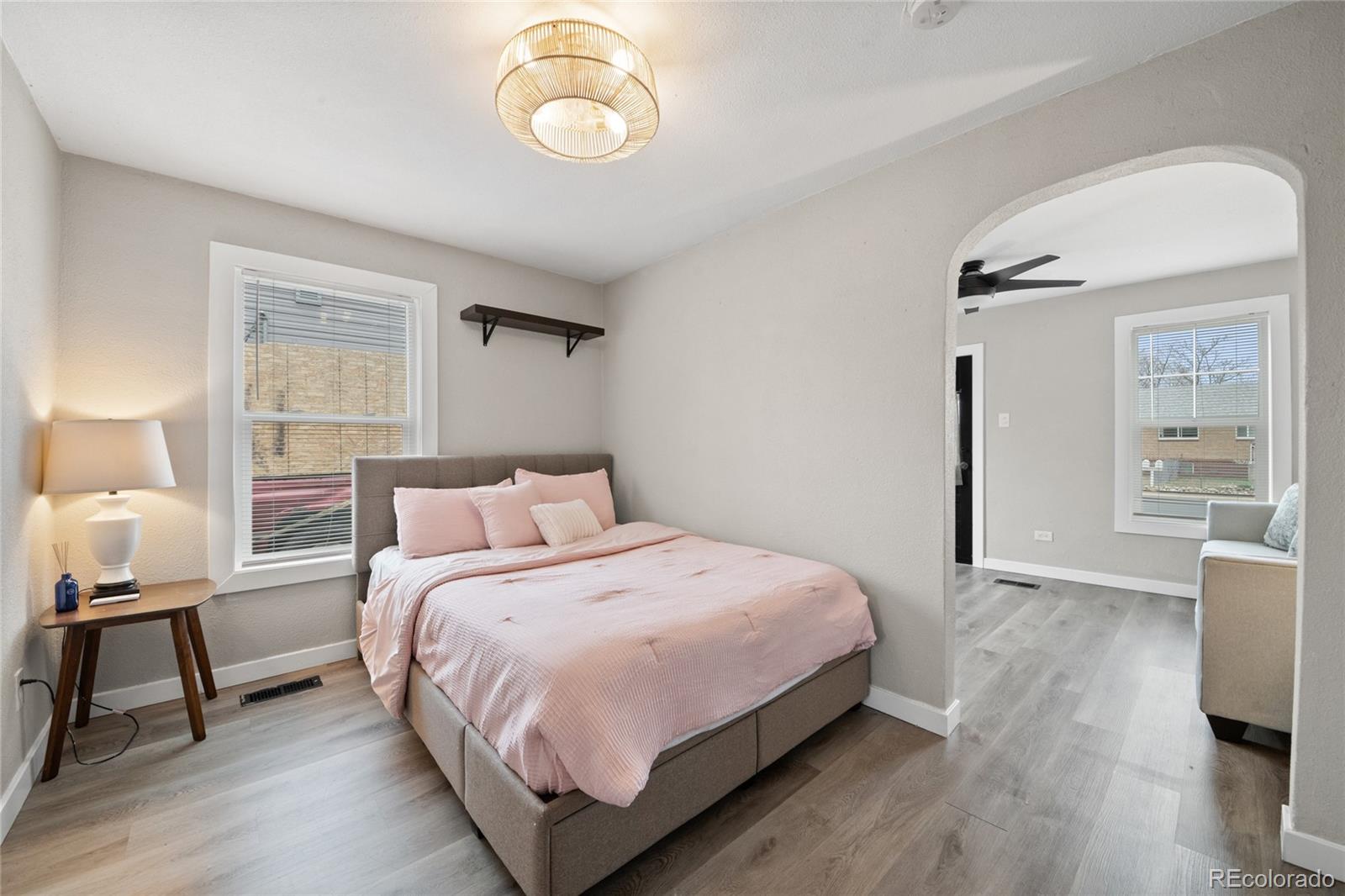 2045 Eaton Street Edgewater, CO 80214 - Photo 13 of 28 a bedroom with a bed and a table in it with wooden floor