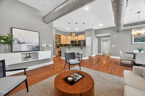 a living room with furniture and a dining table with kitchen view