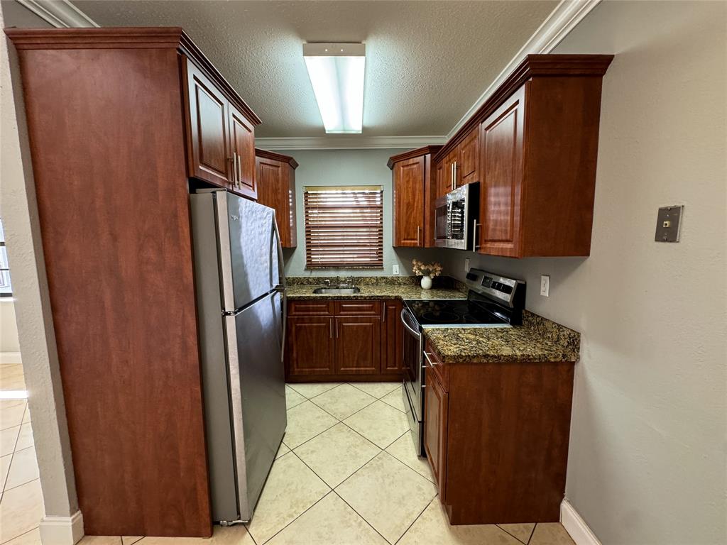 1925 Madison Street, Unit 4 Hollywood, FL 33020 - Photo 3 of 11 a kitchen with stainless steel appliances granite countertop a refrigerator and a stove