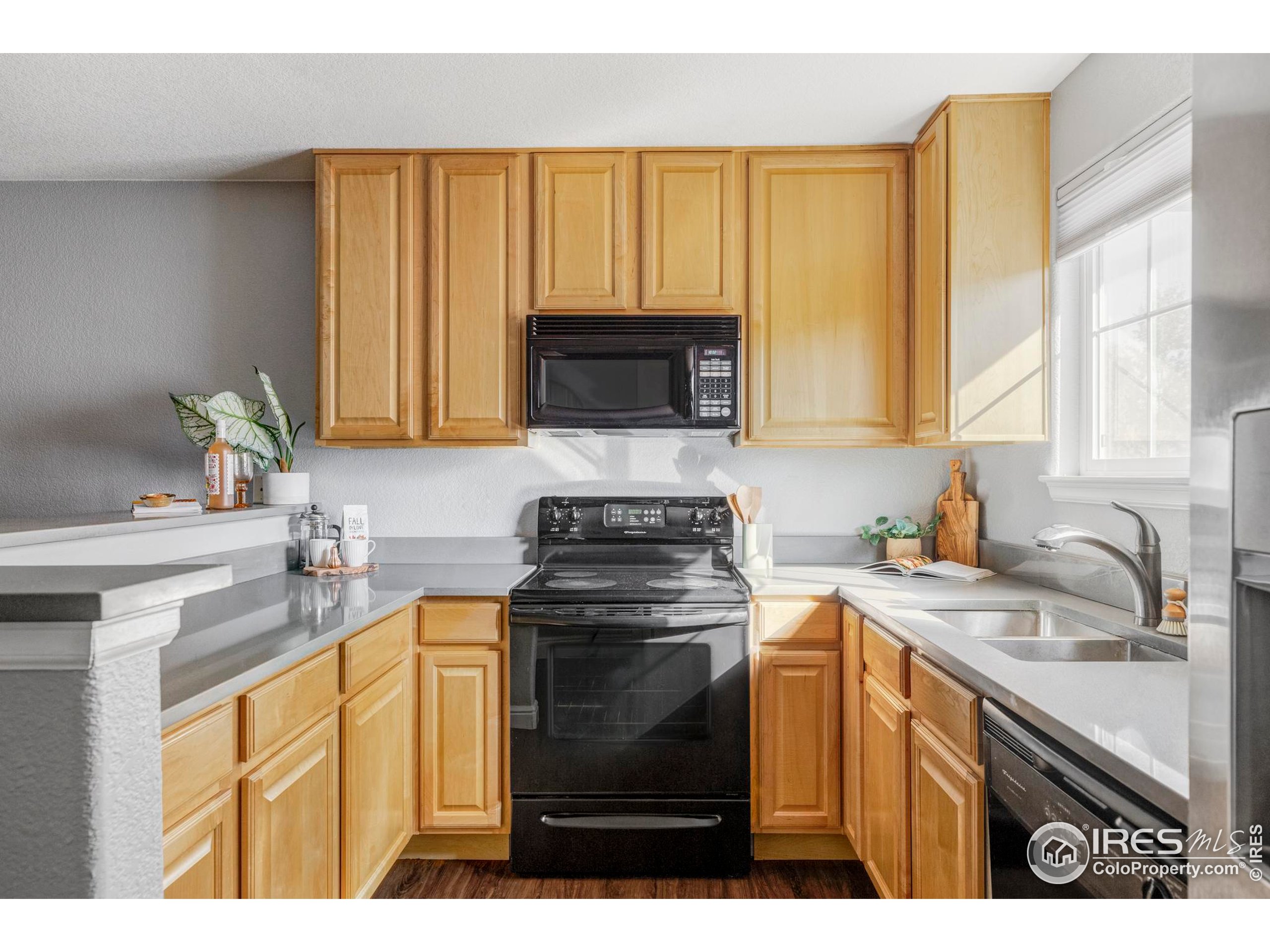 4240 Riley Drive Longmont, CO 80503 - Photo 14 of 25 a kitchen with a stove a sink and a microwave