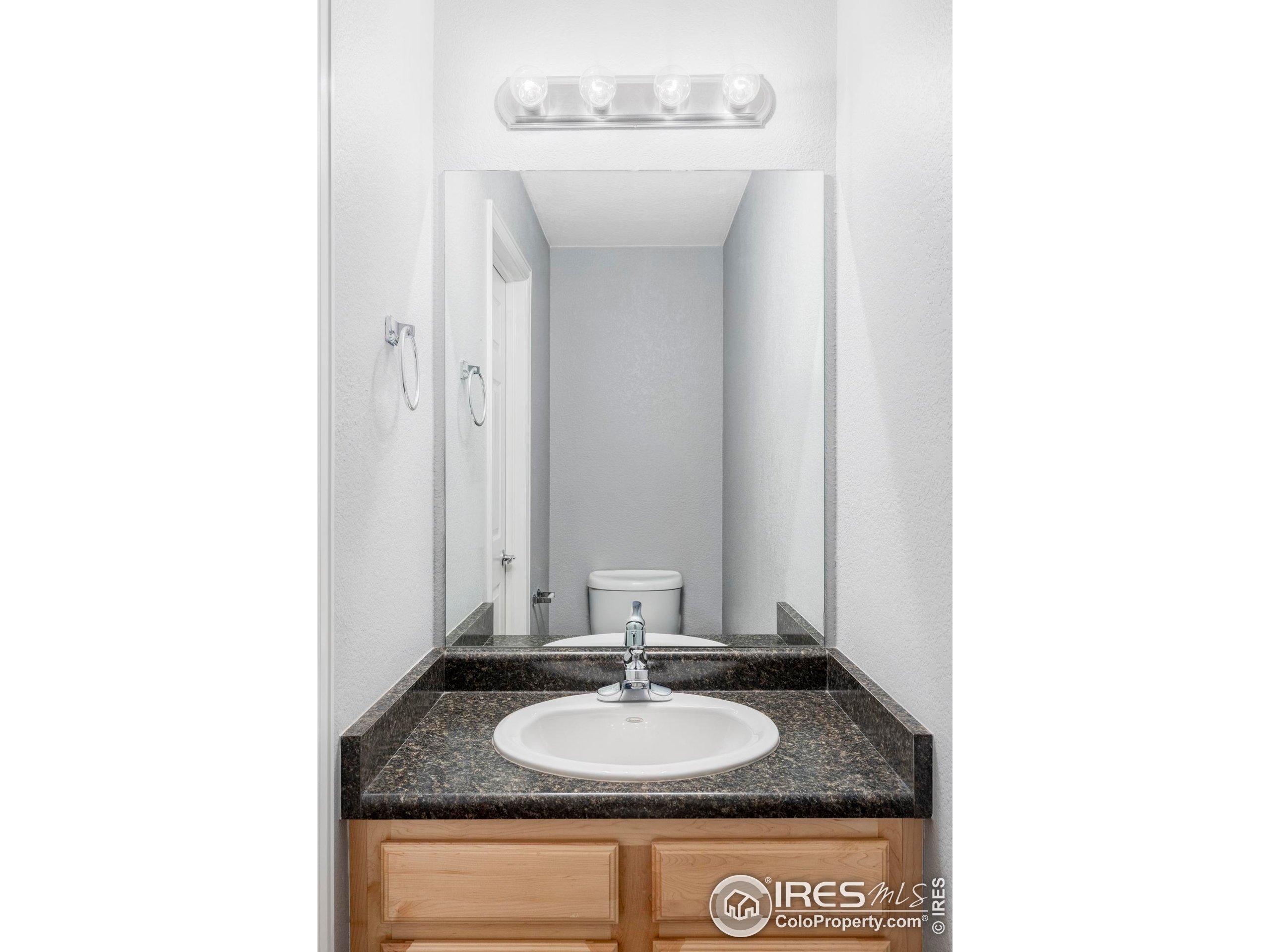 4240 Riley Drive Longmont, CO 80503 - Photo 17 of 25 a bathroom with a granite countertop sink and a mirror