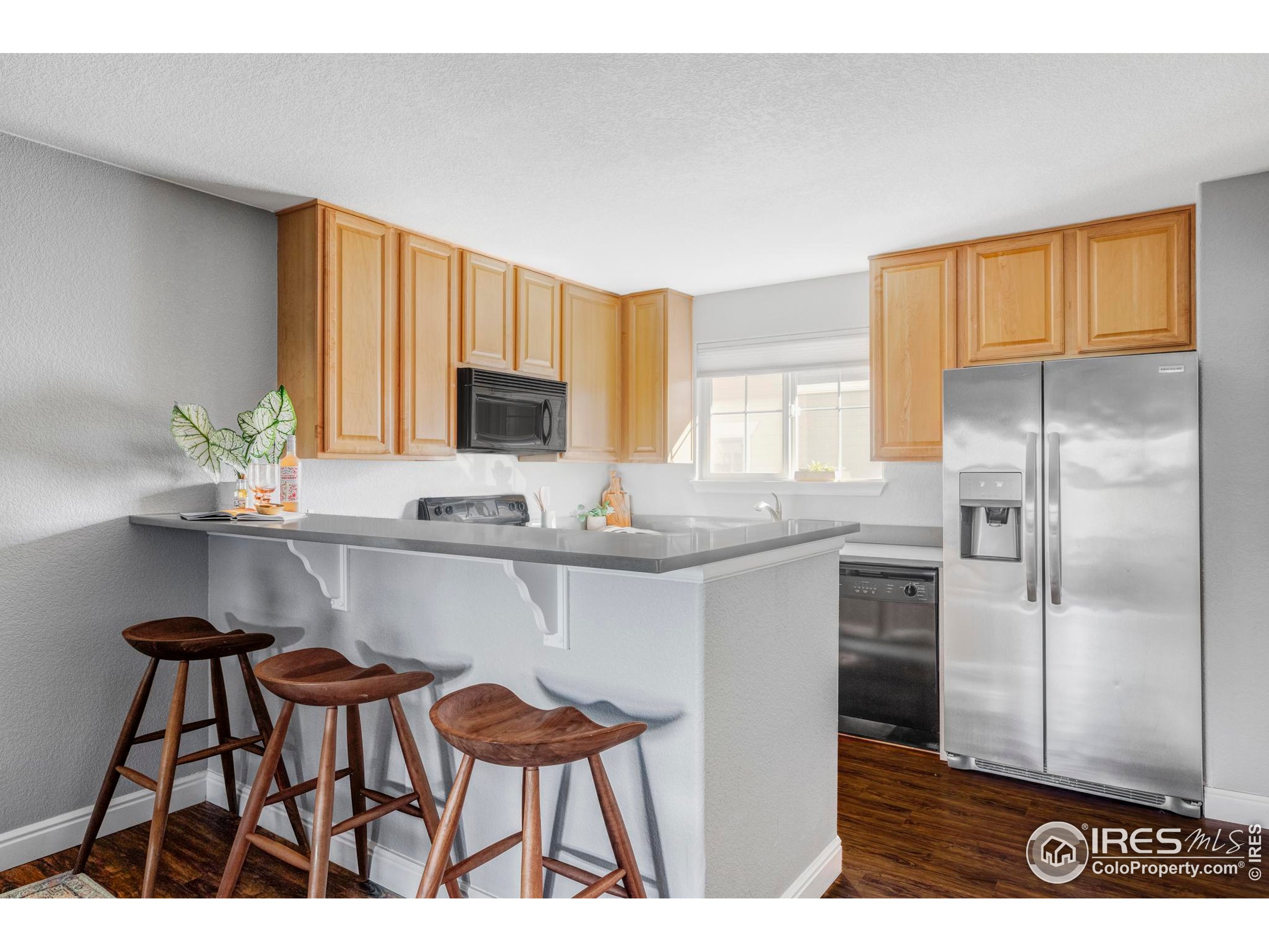4240 Riley Drive Longmont, CO 80503 - Photo 3 of 25 a kitchen with kitchen island a counter top space cabinets and stainless steel appliances