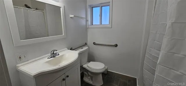 a bathroom with a sink a toilet and a mirror