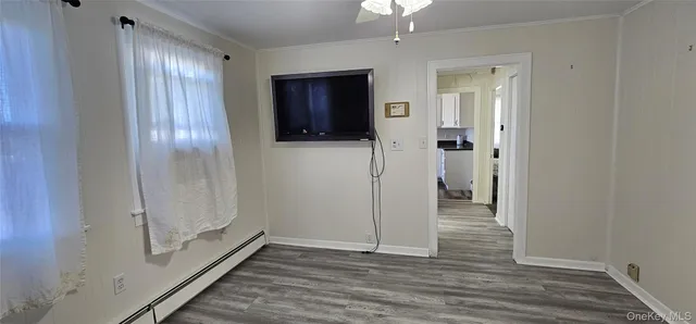 a view of hallway with livingroom and wooden floor
