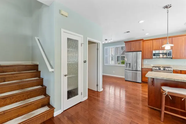 a view of kitchen with stainless steel appliances granite countertop cabinets and wooden floor