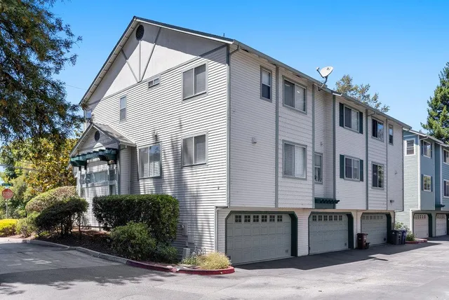 a front view of a house with a tree