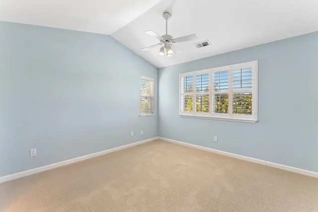 an empty room with a window and ceiling fan