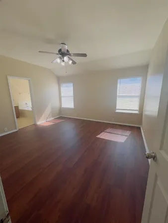 a view of room with window ceiling fan and hardwood floor