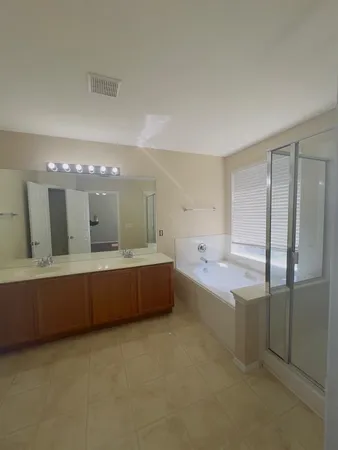 a large kitchen with stainless steel appliances a large counter top and a refrigerator