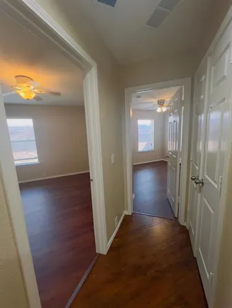 a view of a hallway with wooden floor