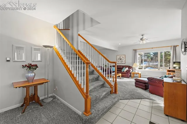 a view of a livingroom with furniture stairs and windows