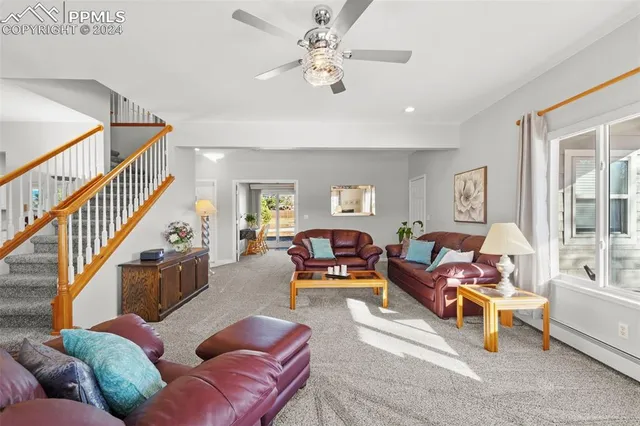 a living room with furniture ceiling fan and a window