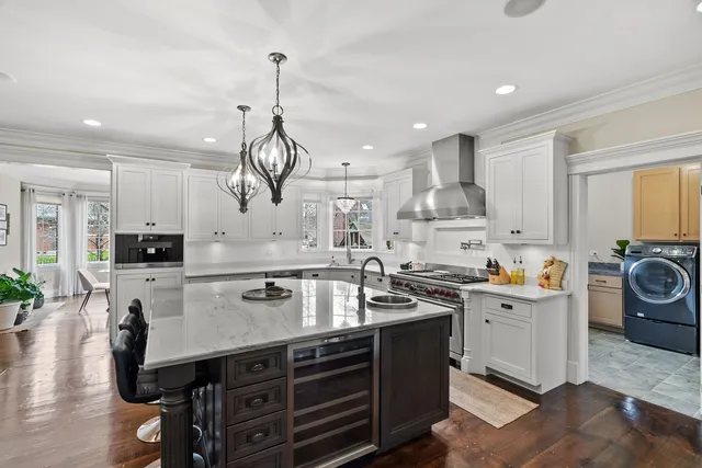 a kitchen with stainless steel appliances granite countertop a sink a stove and a wooden floors