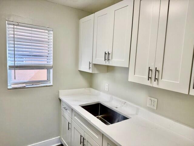 600 Southwest 2nd Avenue, Unit 140 Boca Raton, FL 33432 - Photo 30 of 30 a kitchen with white cabinets and a sink