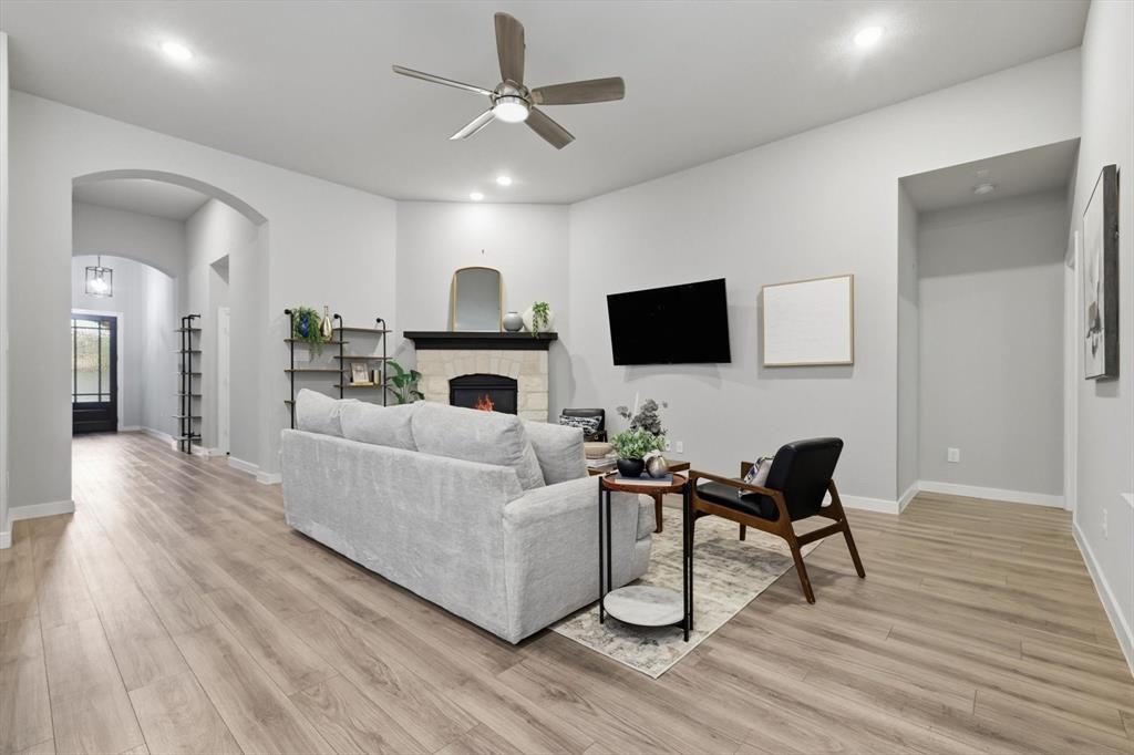 2912 Winding Ridge Court Little Elm, TX 75068 - Photo 13 of 40 Gorgeous open concept living room with built in shelving/storage, gas fireplace, LVP Flooring, Natural light the illuminates this area with an open space to dining and kitchen.