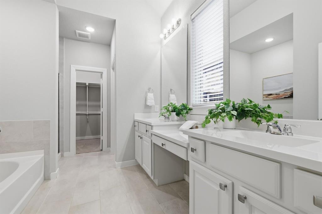 2912 Winding Ridge Court Little Elm, TX 75068 - Photo 21 of 40 Large ensuite bathroom with dual sinks, large soaking tub, walk in shower and large closet! Tons of natural light and modern finishes!