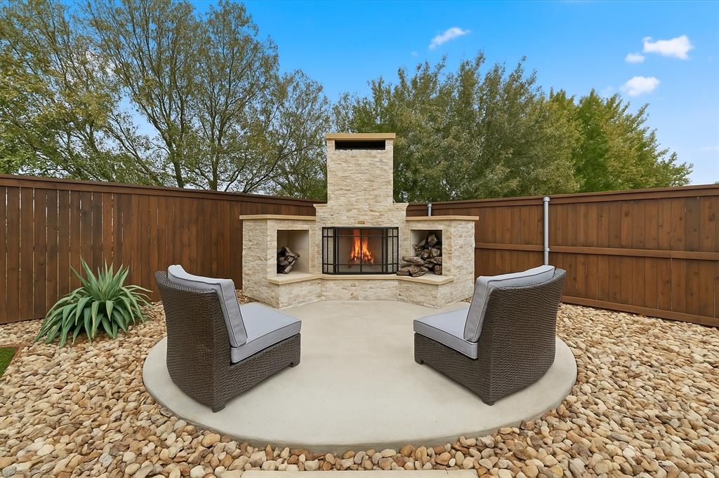 2912 Winding Ridge Court Little Elm, TX 75068 - Photo 5 of 40 Beautiful upgraded back yard with turf, drought tolerant plants, extended patio with a gorgeous outdoor fireplace for cozy gatherings and more!