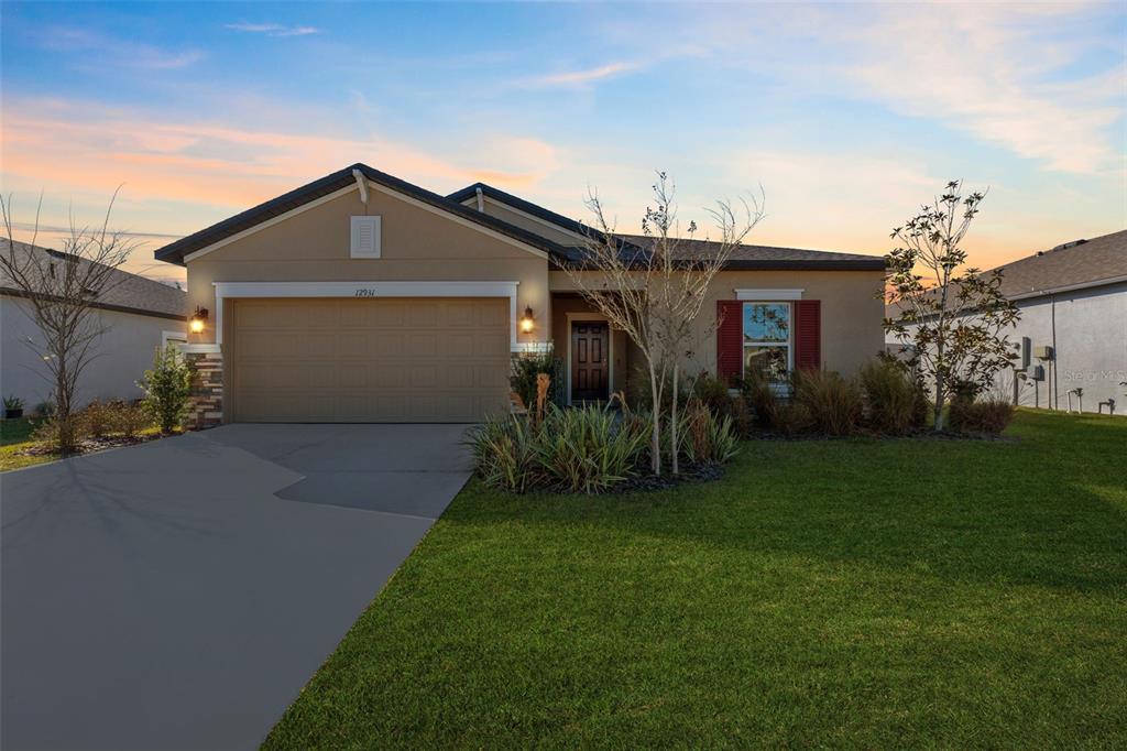 12931 Conquistador Loop Spring Hill, FL 34610 - Photo 1 of 1 a front view of house with yard and green space