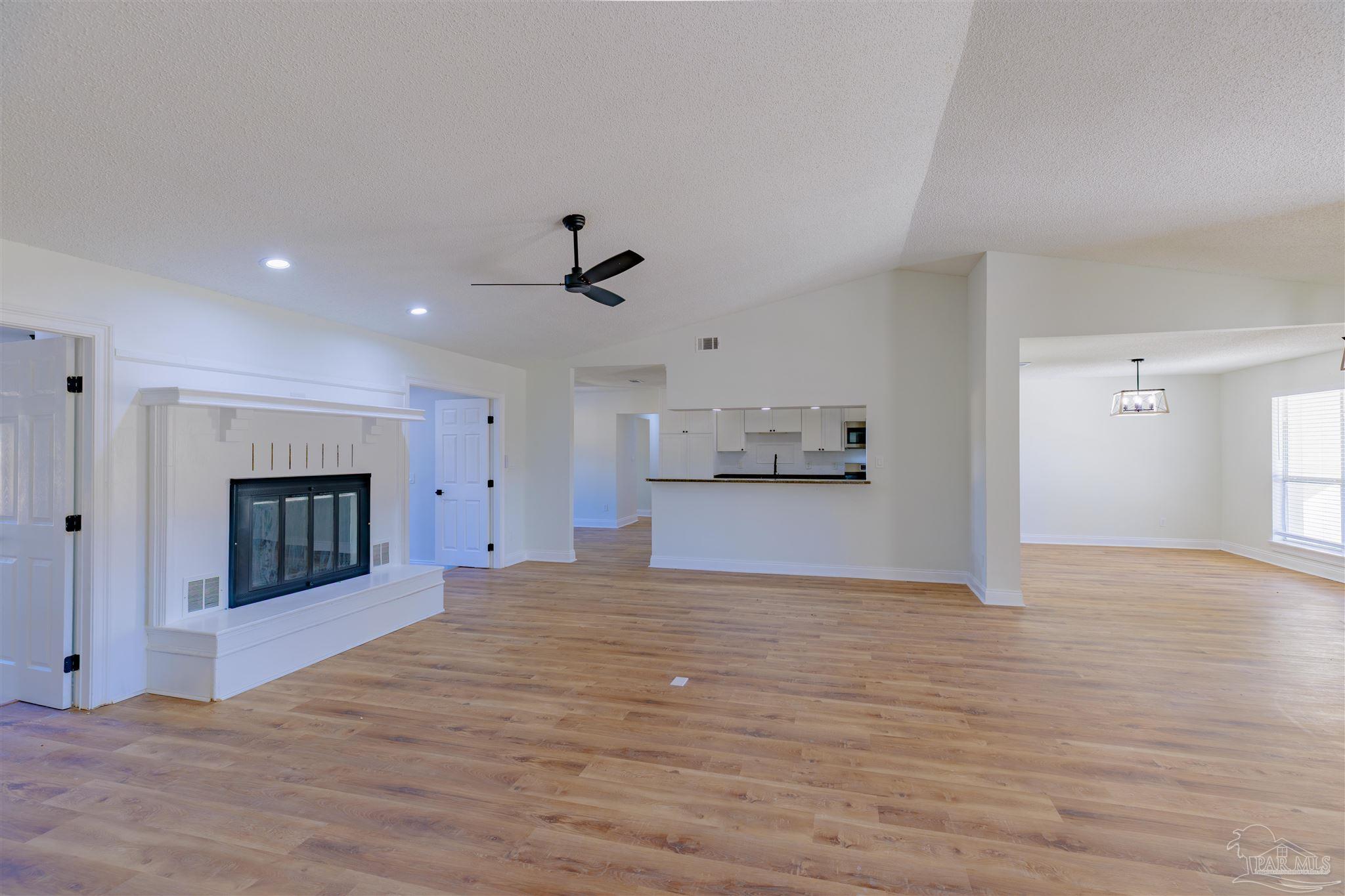 2115 Stallion Road Cantonment, FL 32533 - Photo 14 of 70 a view of empty room with wooden floor and fireplace