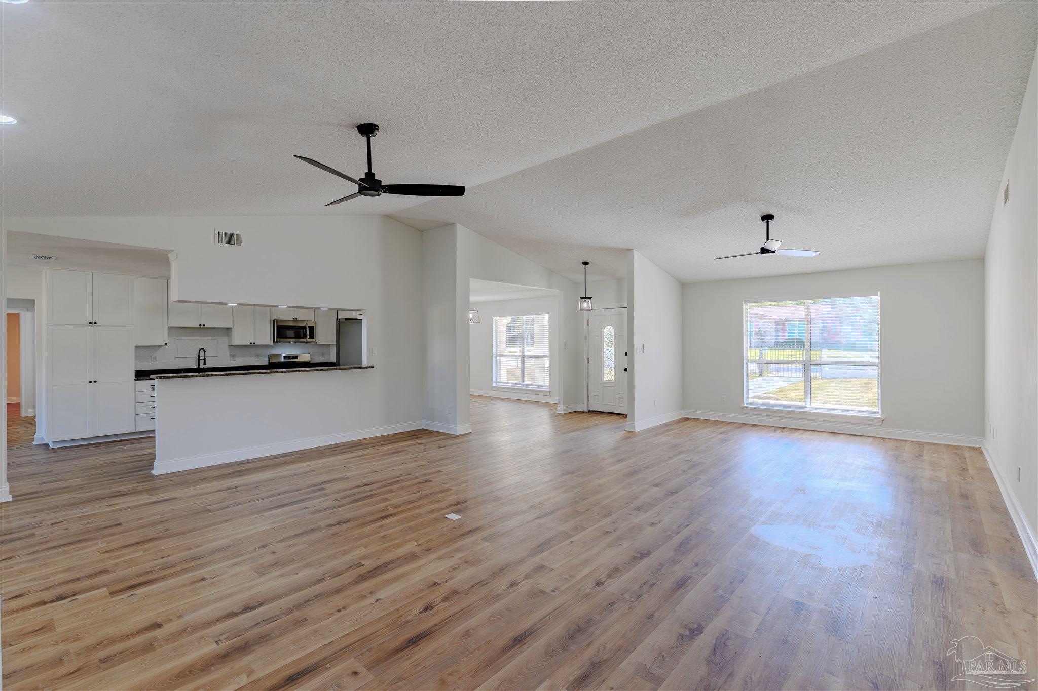 2115 Stallion Road Cantonment, FL 32533 - Photo 15 of 70 a view of an empty room with a window and kitchen view