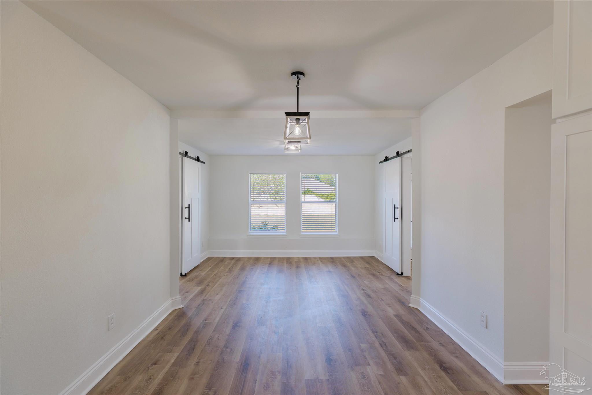 2115 Stallion Road Cantonment, FL 32533 - Photo 23 of 70 a view of an empty room with wooden floor and a window