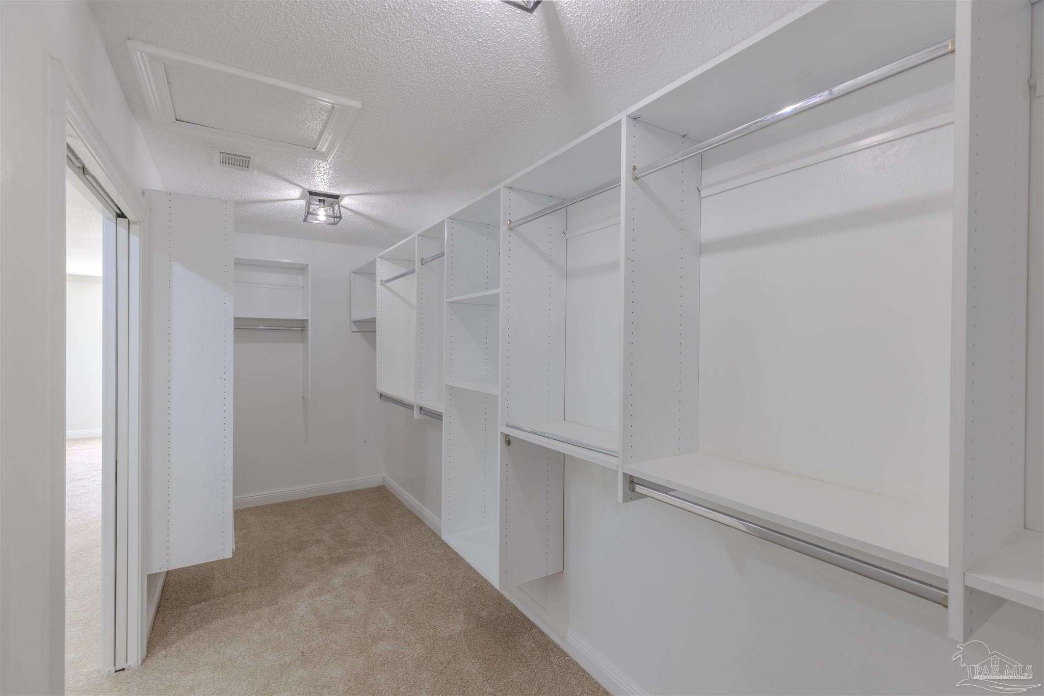 2115 Stallion Road Cantonment, FL 32533 - Photo 35 of 70 a view of walk in closet with empty racks