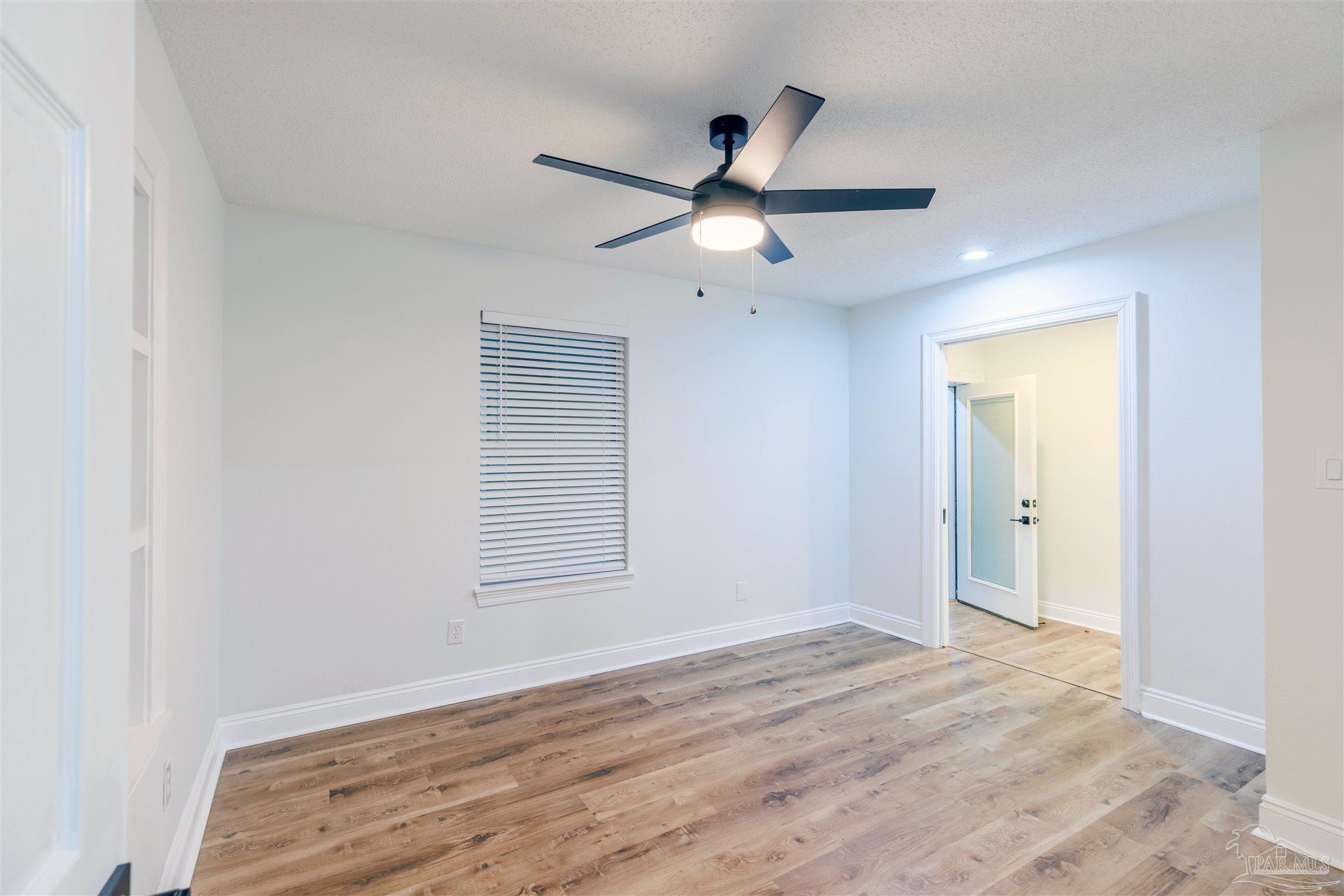 2115 Stallion Road Cantonment, FL 32533 - Photo 47 of 70 a view of an empty room with wooden floor and a ceiling fan