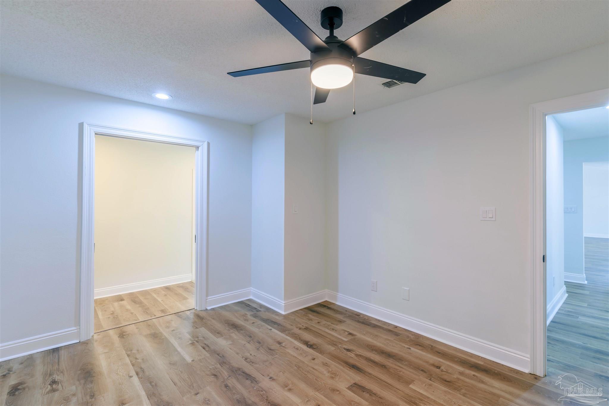 2115 Stallion Road Cantonment, FL 32533 - Photo 48 of 70 an empty room with wooden floor and fan