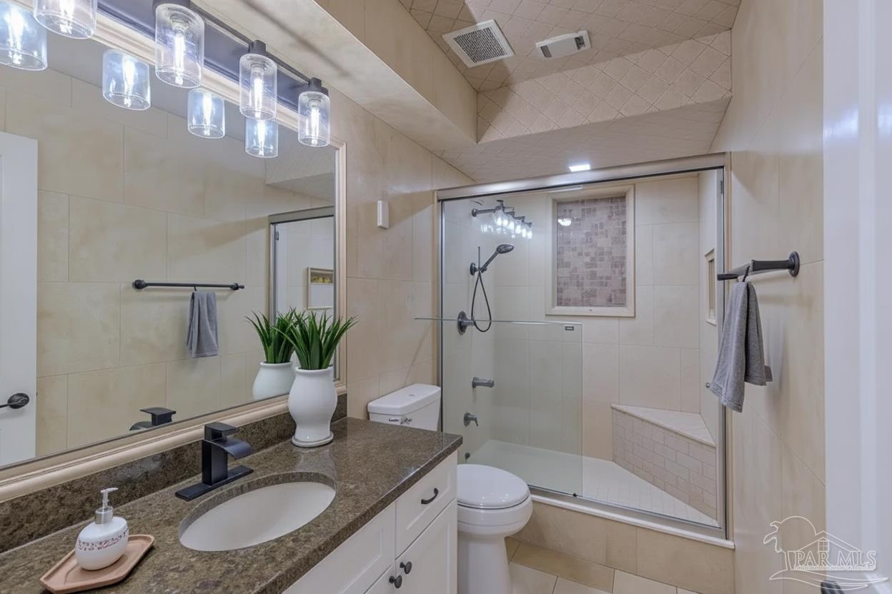 2115 Stallion Road Cantonment, FL 32533 - Photo 53 of 70 a bathroom with a granite countertop sink toilet a large mirror a shower and a mirror