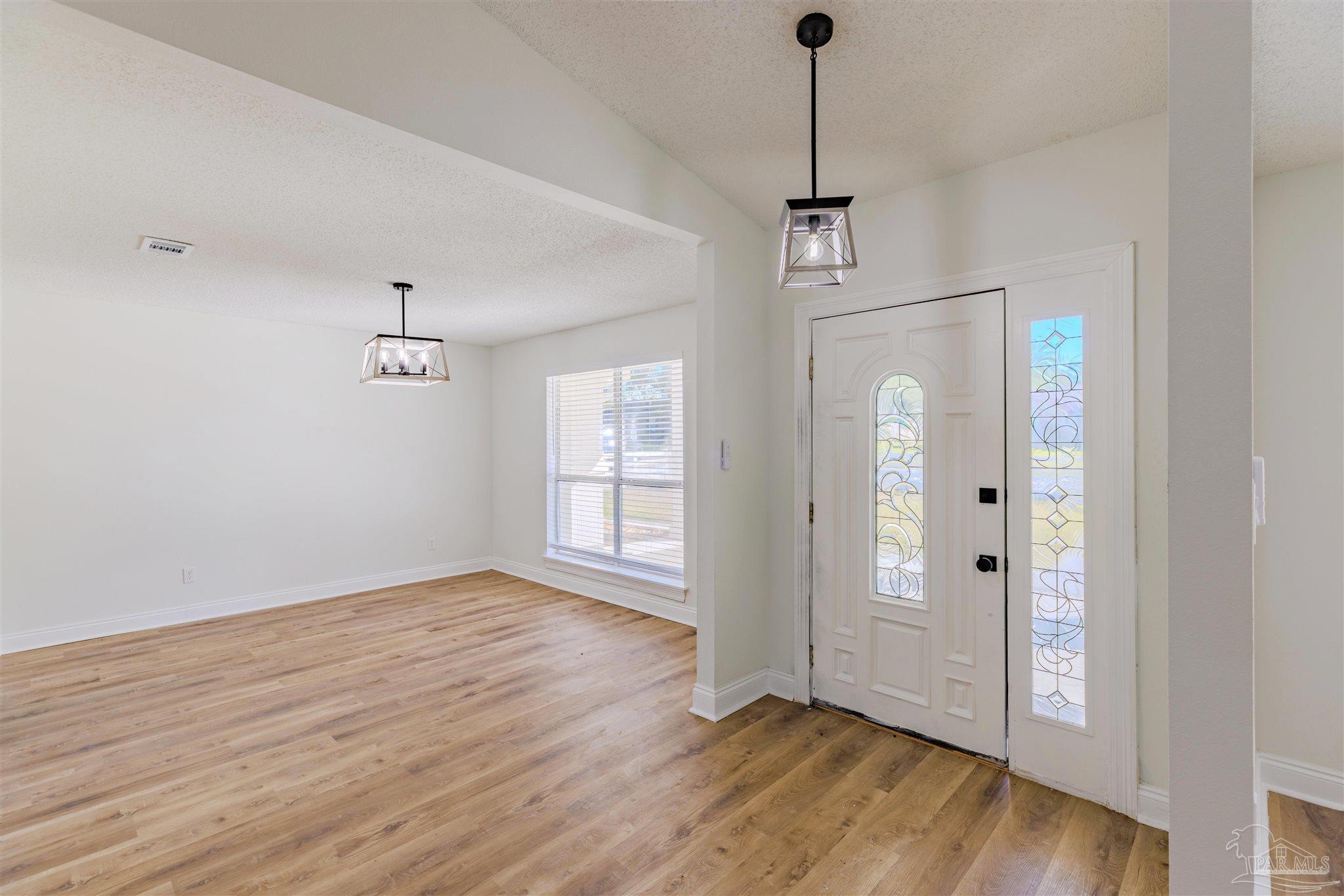 2115 Stallion Road Cantonment, FL 32533 - Photo 7 of 70 a view of an empty room with wooden floor and a window