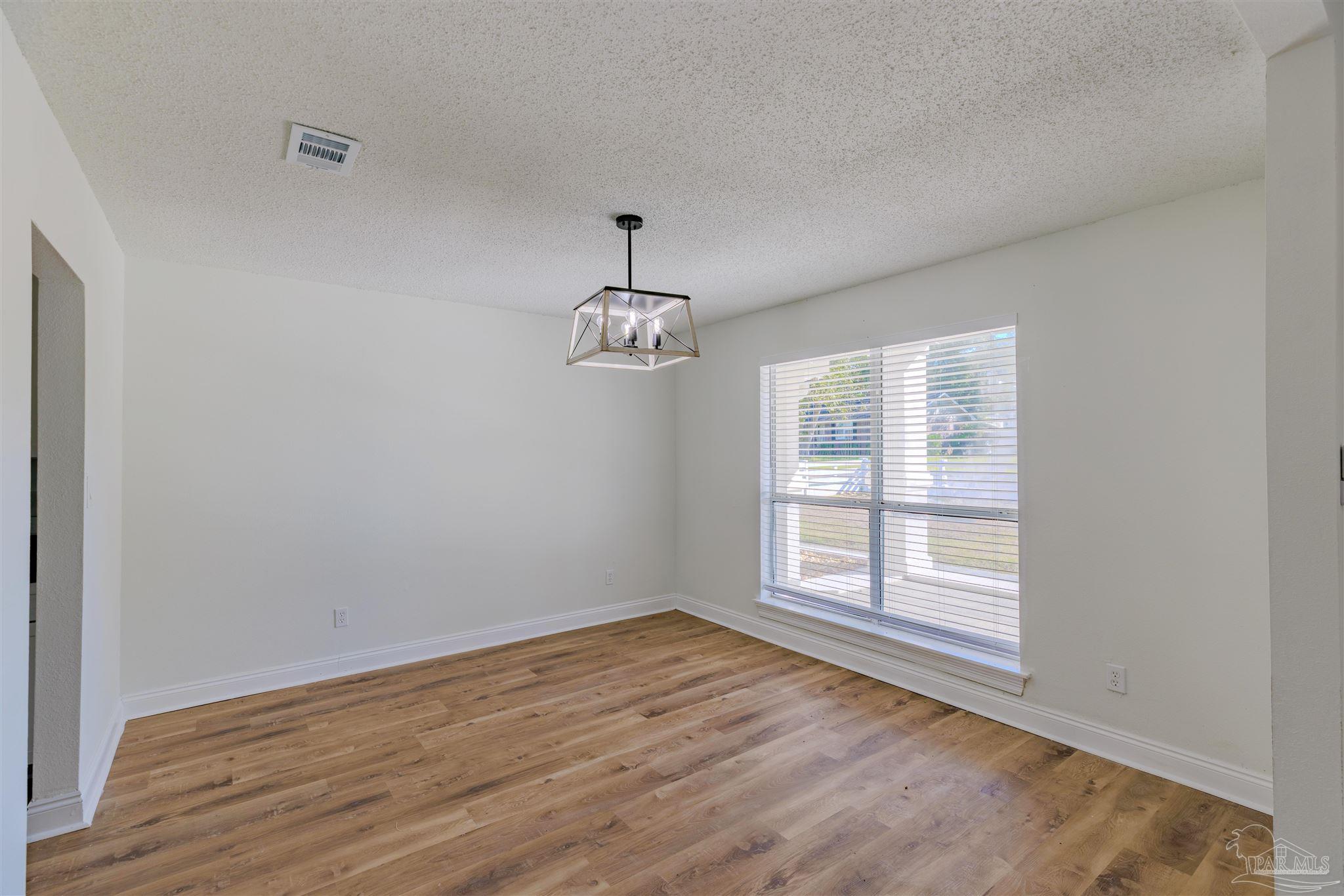 2115 Stallion Road Cantonment, FL 32533 - Photo 8 of 70 wooden floor in an empty room with a window