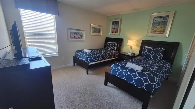 a bedroom with two beds and painting on the wall