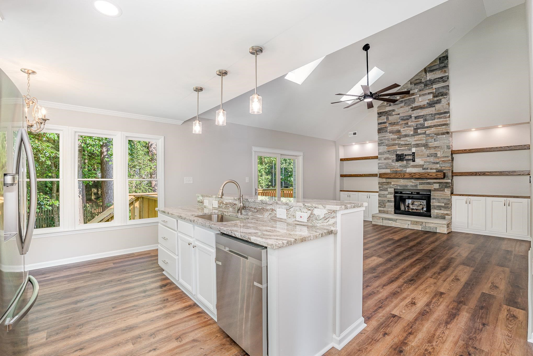 4924 Knightsbridge Way Raleigh, NC 27604 - Photo 9 of 27 a kitchen with kitchen island a counter top a stove and a wooden floors
