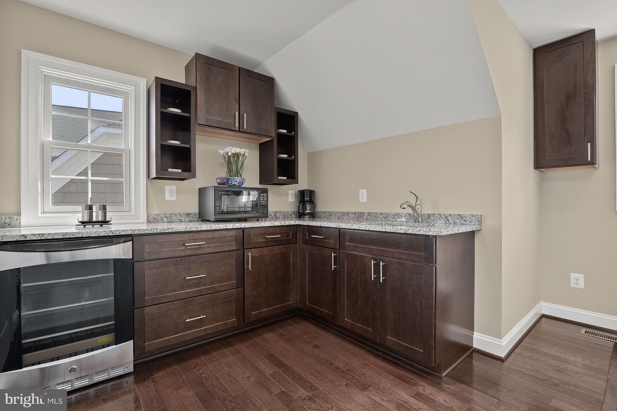 21151 Mill Branch Drive Leesburg, VA 20175 - Photo 109 of 132 a kitchen with granite countertop wooden cabinets and white appliances
