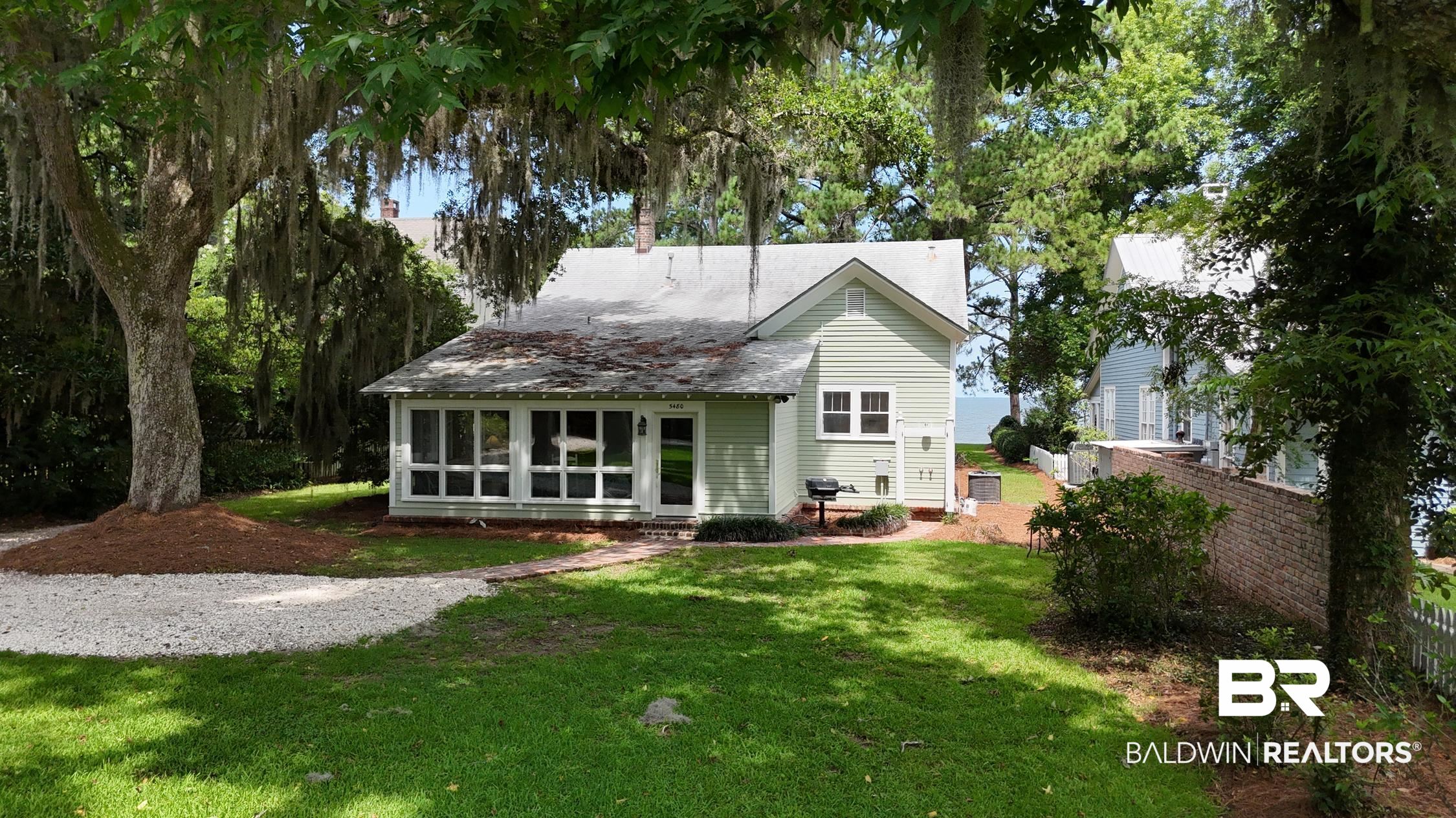 5480 Battles Road Fairhope, AL 36532 - Photo 1 of 48 Gabled residence featuring light green siding and a white-framed sunroom