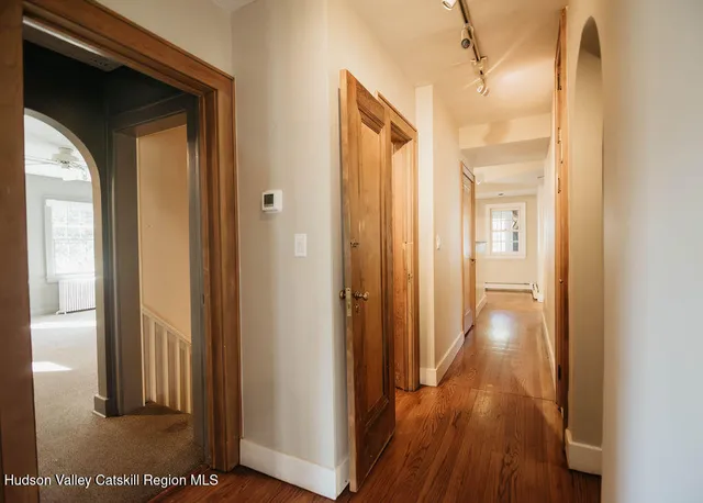 a view of a hallway with wooden floor
