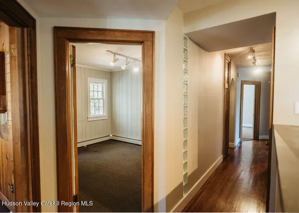 a view of a hallway with wooden floor
