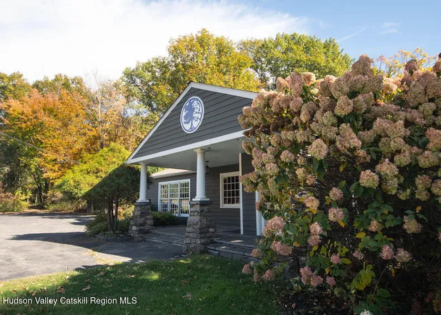 a view of a house with a small yard and tree s