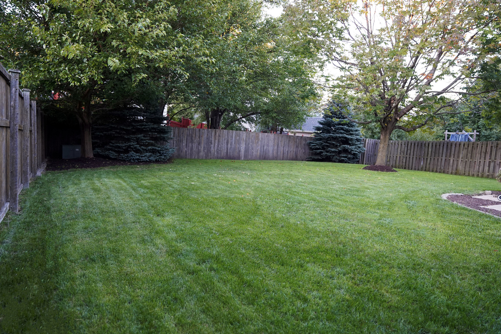 24300 White Oak Drive Plainfield, IL 60585 - Photo 11 of 32 a view of a backyard with large trees and wooden fence