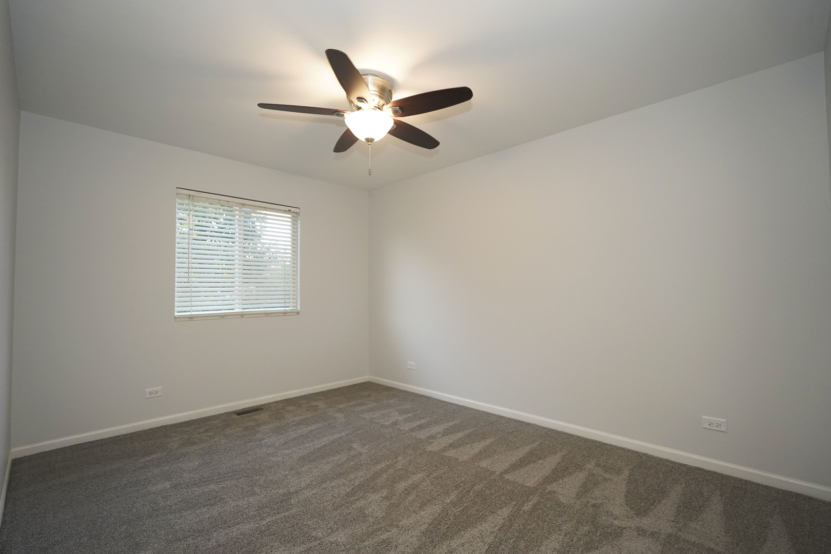 24300 White Oak Drive Plainfield, IL 60585 - Photo 24 of 32 an empty room with a window and a fan