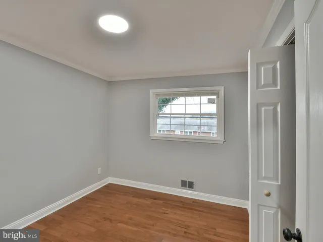 a view of empty room with wooden floor