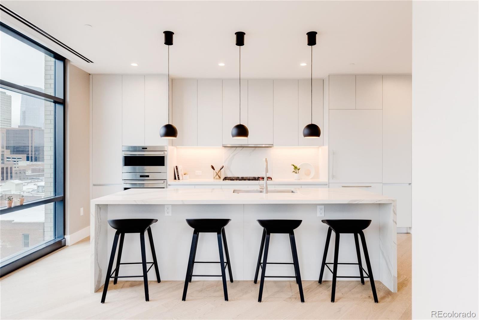 a kitchen with stainless steel appliances kitchen island granite countertop a table chairs in it and white cabinets