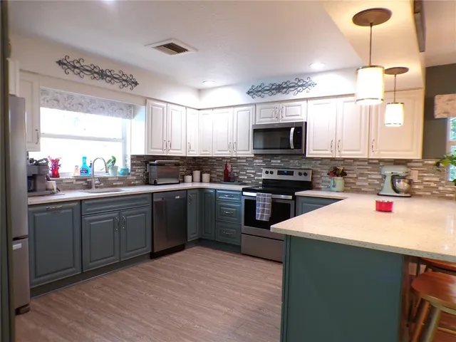 a kitchen with a dining table chairs sink and cabinets
