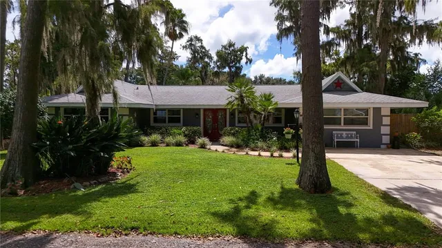 a view of a house with a yard and potted plants