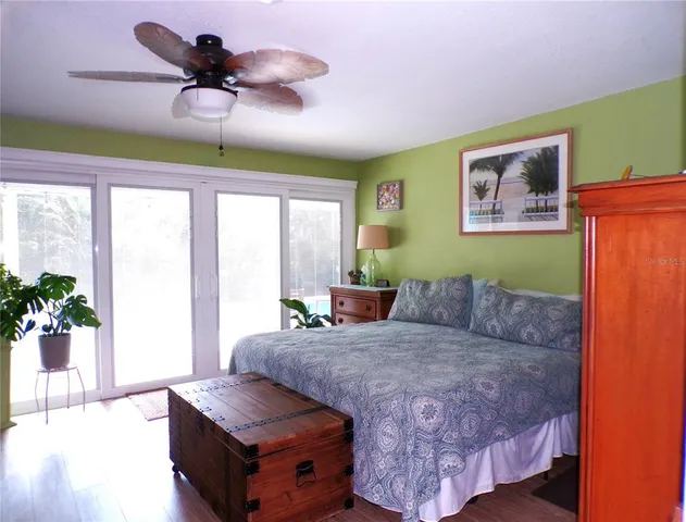 a bedroom with a bed a large window and walk in closet