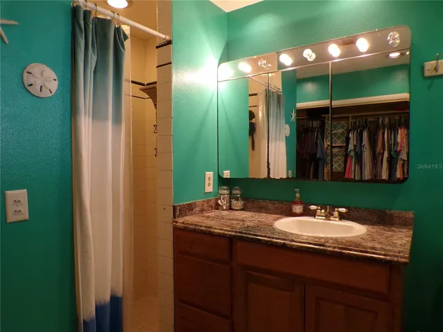 a view of swimming pool with lawn chairs and plants